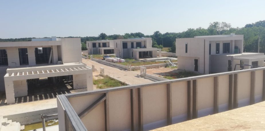 Maison Individuelle en Charpente Métallique Vista panoramique d'un complexe résidentiel en construction, avec plusieurs bâtiments modernes.